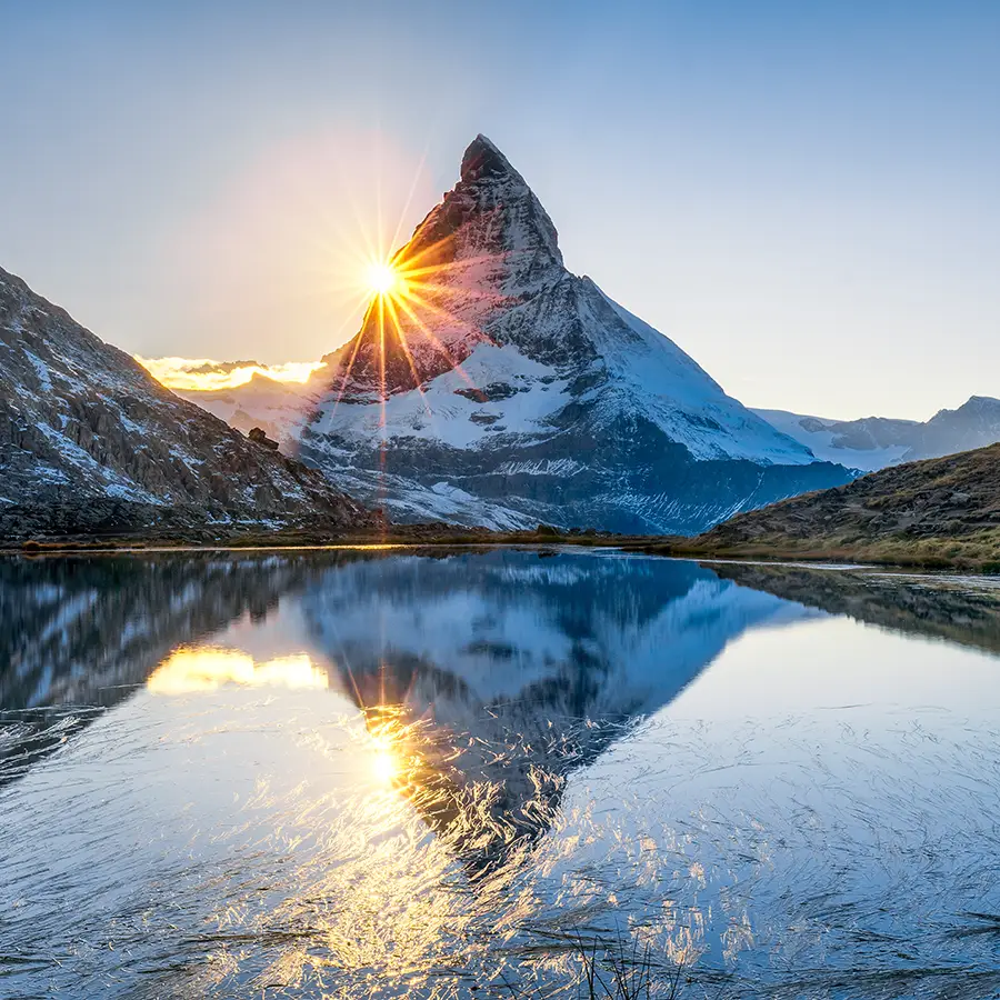 Berg an einem See mit Sonnenaufgang